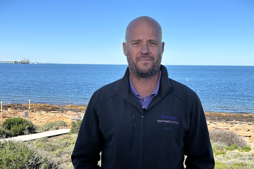 A man stands with the water of the Spencer Gulf in the background