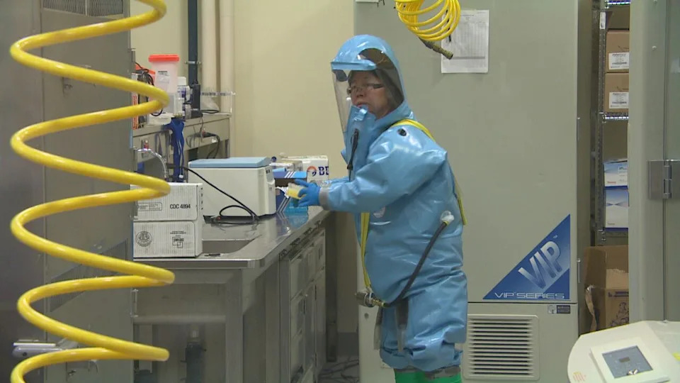 Xiangguo Qiu wears a biocontainment suit while working in the containment lab at the National Microbiology Lab (NML) in Winnipeg. Qiu, her biologist husband Keding Cheng, and her students were escorted out of the NML in July 2019. Qiu and Cheng were fired in January 2021.