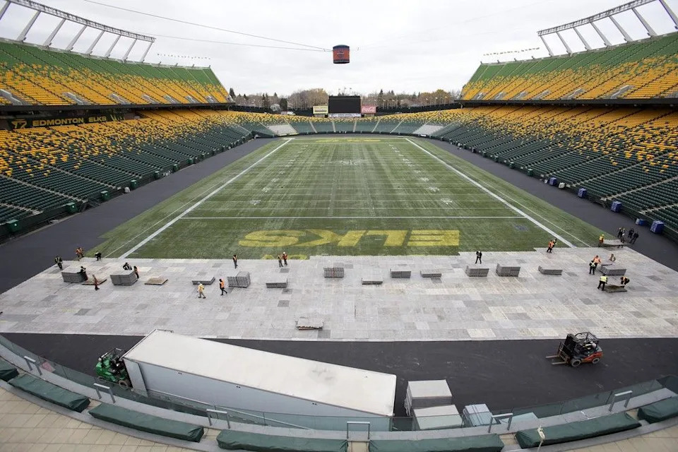  Crews lay down plastic flooring as they begin the process of creating an outdoor hockey rink at Commonwealth Stadium for the Heritage Classic in Edmonton on Oct. 17, 2023.