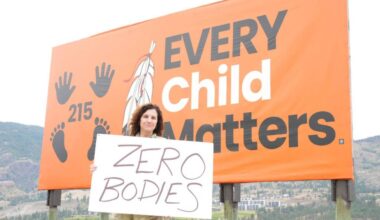 Vancouver-Quilchena MLA Dallas Brodie, of OneBC, stands in front of an Every Child Matters sign on Penticton Indian Band land, holding a sign of her own that reads &lsquo;Zero bodies.&rsquo; (@Dallas_Brodie/X).