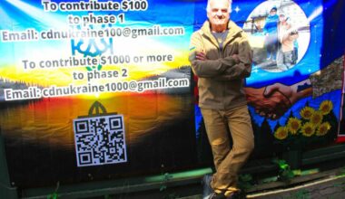 Cloverdale paramedic Will Rogers stands beside a banner he made up to advertise for a new investment fund he started to help both Ukraine and Canada. (Photo: Malin Jordan/Cloverdale Reporter)