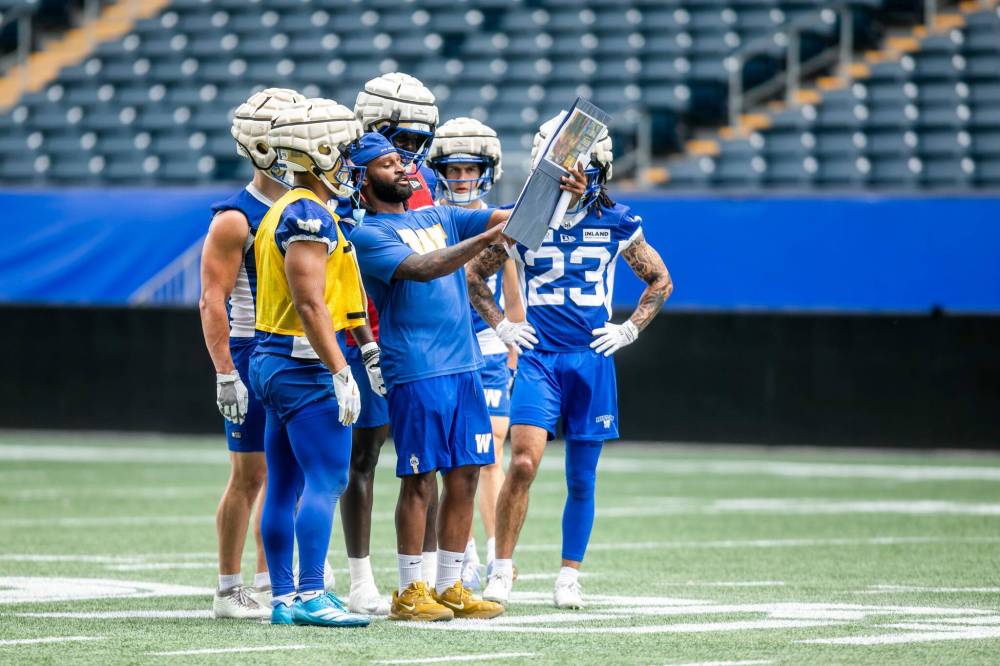 MIKAELA MACKENZIE / FREE PRESS
Winnipeg Blue Bombers receivers coach Bralon Addison (centre) shows goes over a play at Tuesday’s practice. The recently retired Ottawa Redblack was officially hired by the Blue and Gold on Monday.