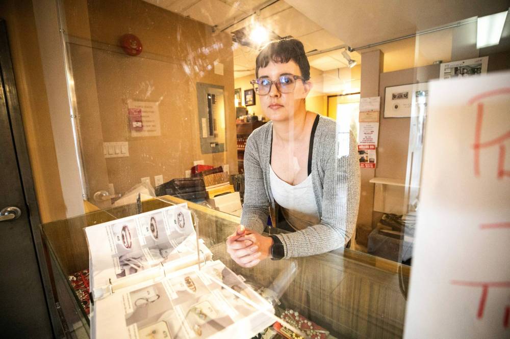 MIKAELA MACKENZIE / FREE PRESS
Jasmine Allen, vice-president at Gatewest Coin, with a catalogue showing jewelry similar to the items that were stolen by two armed, masked men on Friday.