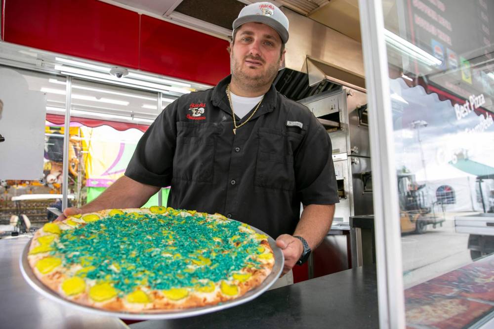 BROOK JONES/FREE PRESS
Rick’s Pickle Pizza owner Tristin Ukmar shows off his deep-fried pickle pizza pie.