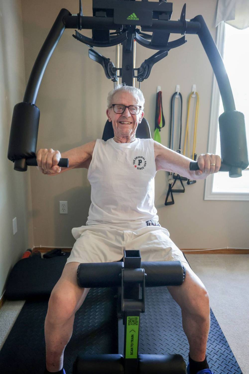 RUTH BONNEVILLE / FREE PRESS
Elliott on his gym equipment doing a chest press which he trains on everyday.