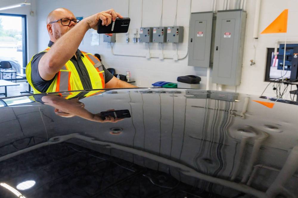 MIKE DEAL / FREE PRESS
MPI Estimator, Mike Head, checks out the hail damage to a claimant’s car.