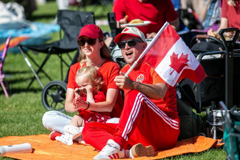 BROOK JONES / FREE PRESS
Matt Milne, right, cheers for Team Canada with his wife Carmen Milne and their daughter Olive.