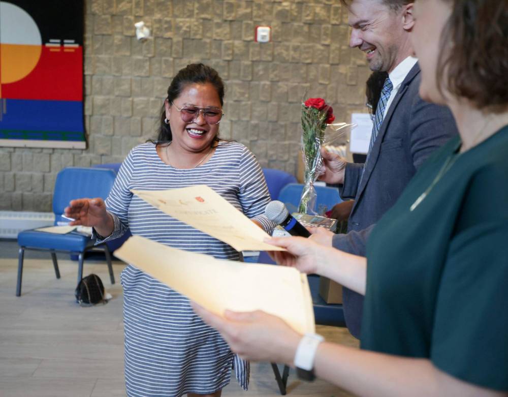 RUTH BONNEVILLE / FREE PRESS
Princess Nakpil receives her graduation certificate from Seyward Goodhand, the creative writing instructor and Aaron Klassen, Shelter U program director, in the chapel at the Salvation Army Thursday.