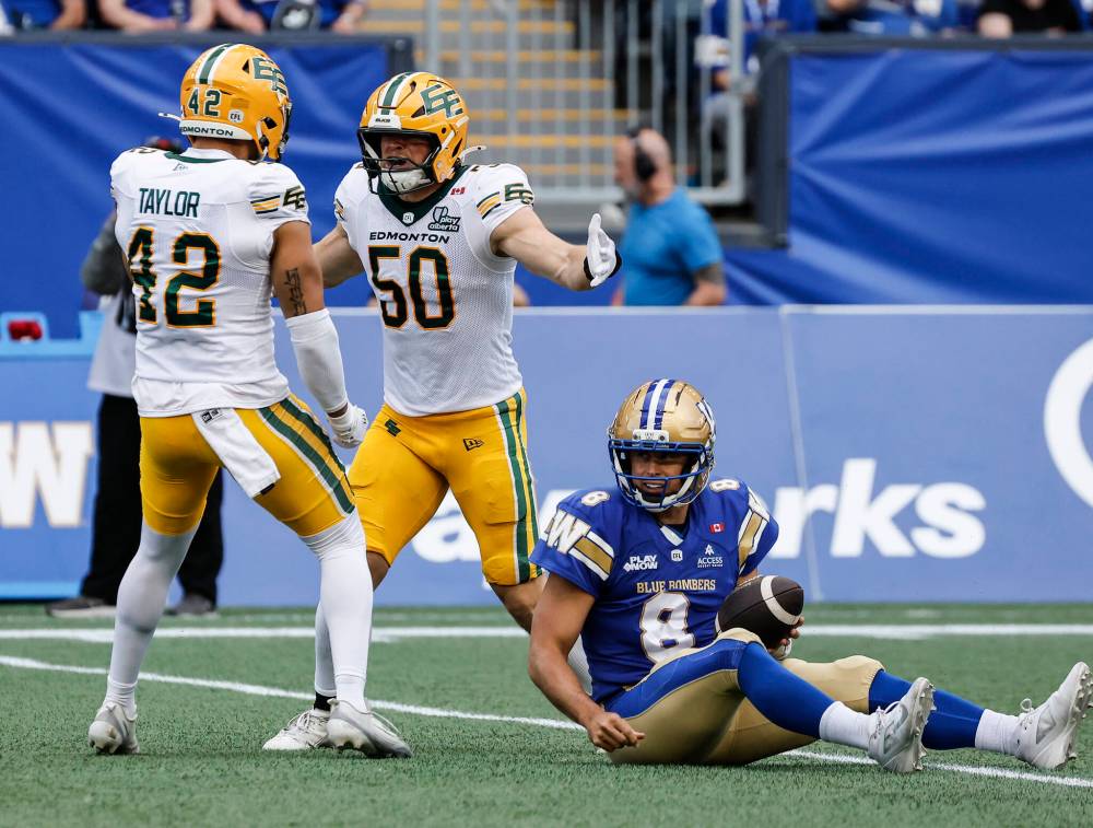 THE CANADIAN PRESS/John Woods
The Edmonton Elks’ Joel Dublanko and Noah Taylor celebrate sacking Winnipeg Blue Bombers quarterback Zach Collaros during the first half of the Elks 23-18 win in Winnipeg, Thursday.