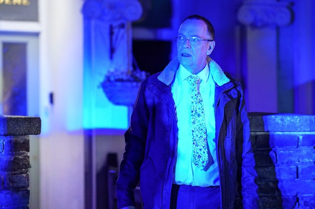 Ian looks shocked as blue lights illuminate his home in EastEnders