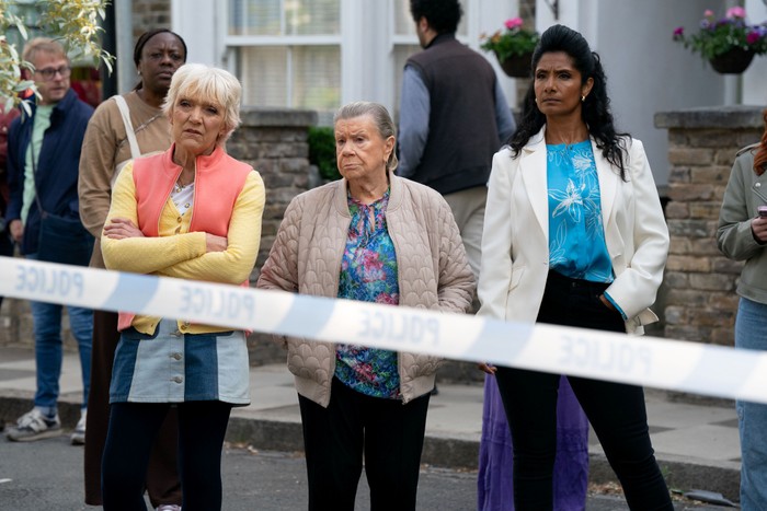 566583,TITLE:Eastenders Jean, Mo and Suki stand behind a police cordon in EastEnders