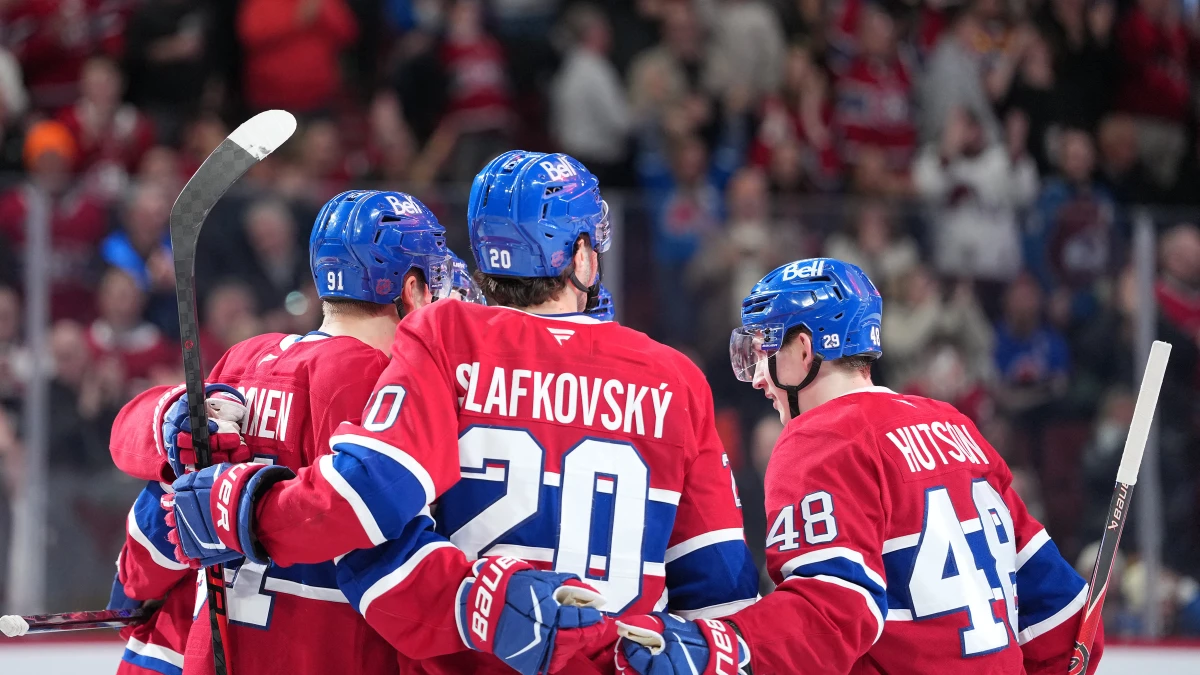 Montreal Canadiens forward Juraj Slafkovsky (20) celebrates with teammates forward Oliver Kapanen (91) and defenseman Lane Hutson (48) after scoring a goal against the Colorado Avalanche during the third period at the Bell Centre.