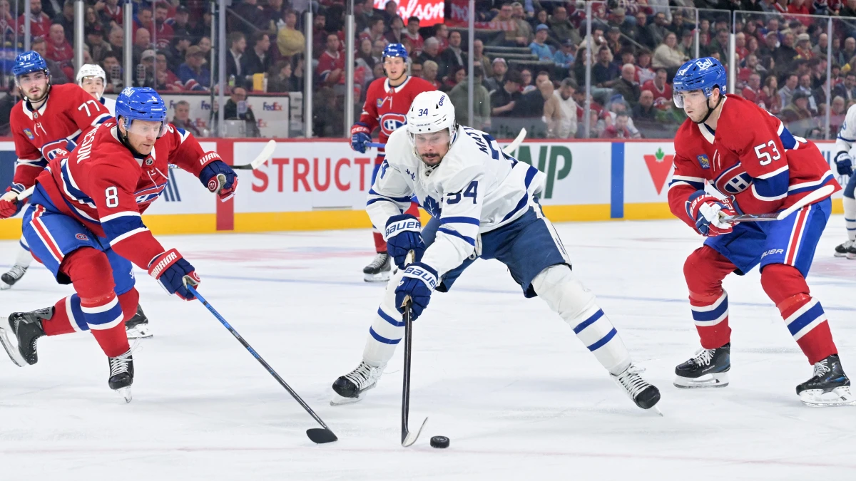 Toronto Maple Leafs forward Auston Matthews (34) plays the puck against Montreal Canadiens defensemen Mike Matheson (8) and Noah Dobson (53) during the third period at the Bell Centre.