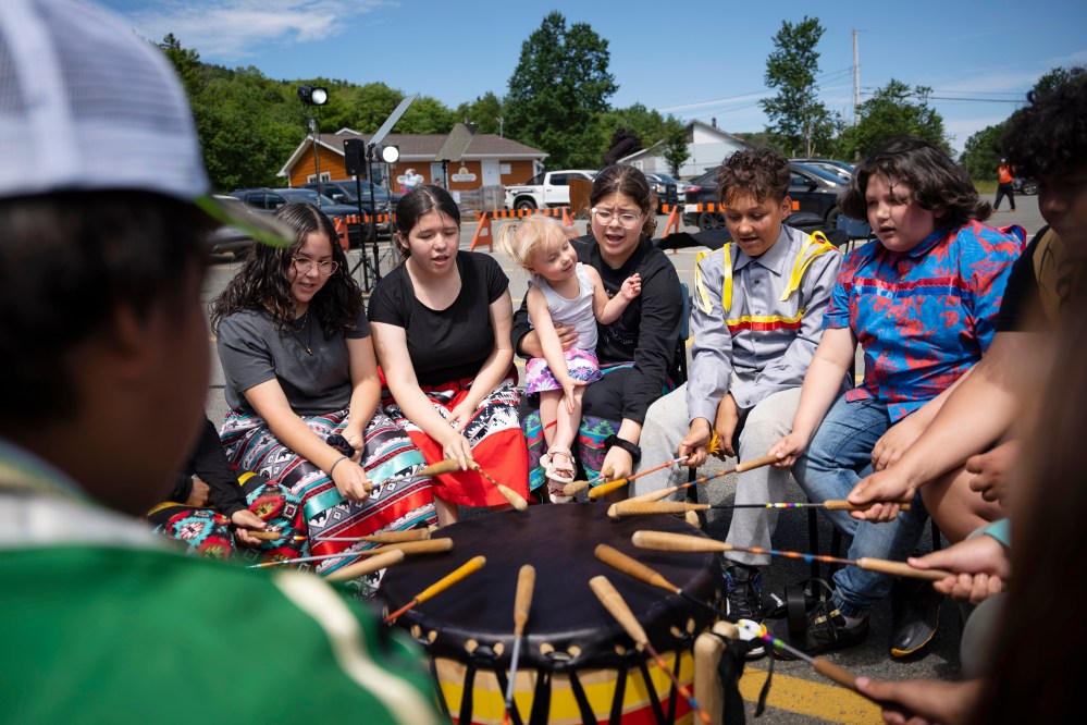 Members of the We’koqma’q Mikmaw school drum group White Bear practise before an event for National Indigenous Peoples Day in We'koqma'q First Nation, N.S., on Friday, June 21, 2024. THE CANADIAN PRESS/Darren Calabrese