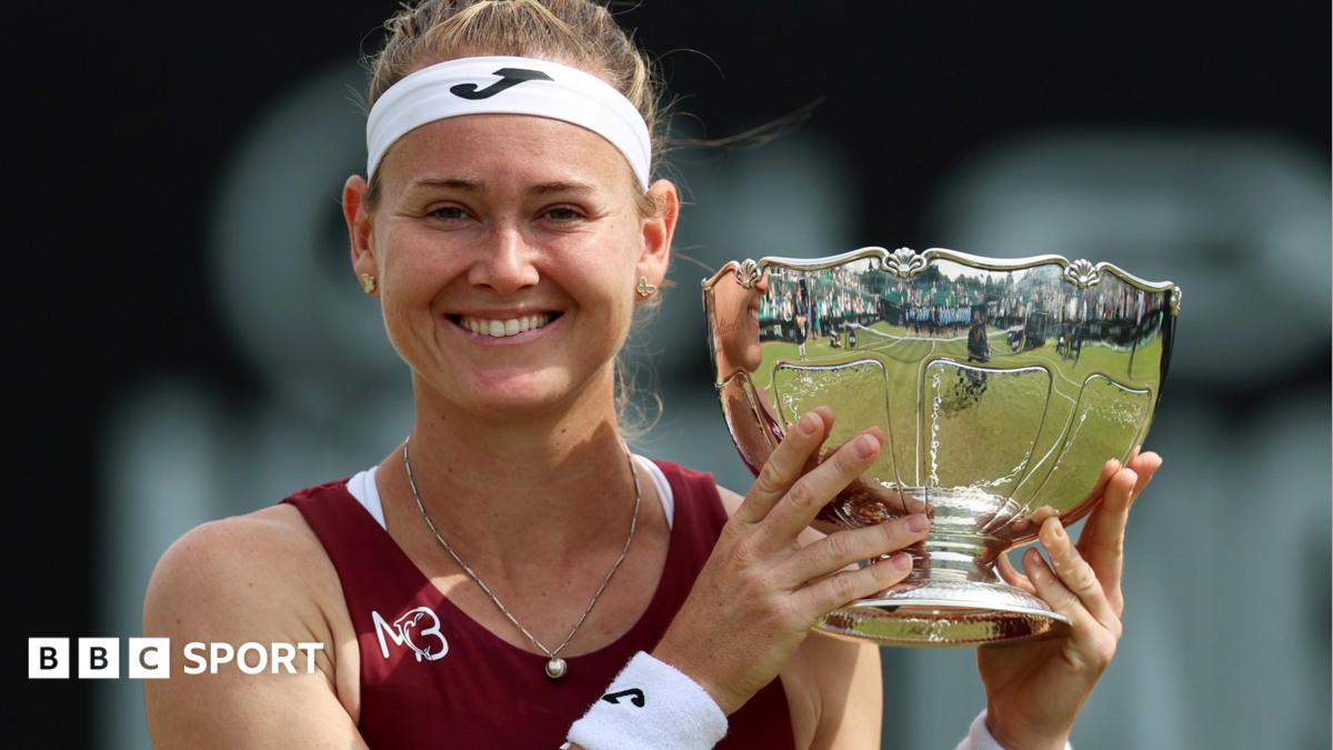 Marie Bouzkova smiles as she holds the Nottingham Open trophy