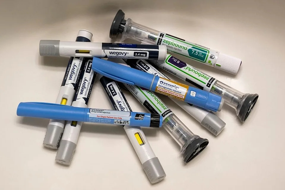 A pile of various injectable medication pens labeled Wegovy and Ozempic, arranged in a small heap