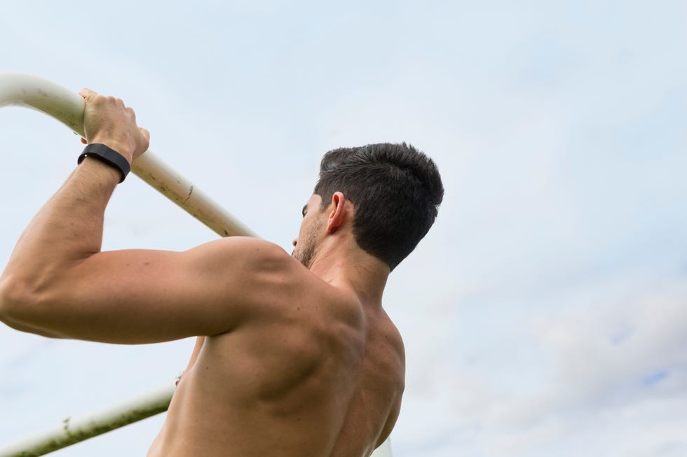 athlete doing chin ups outdoors