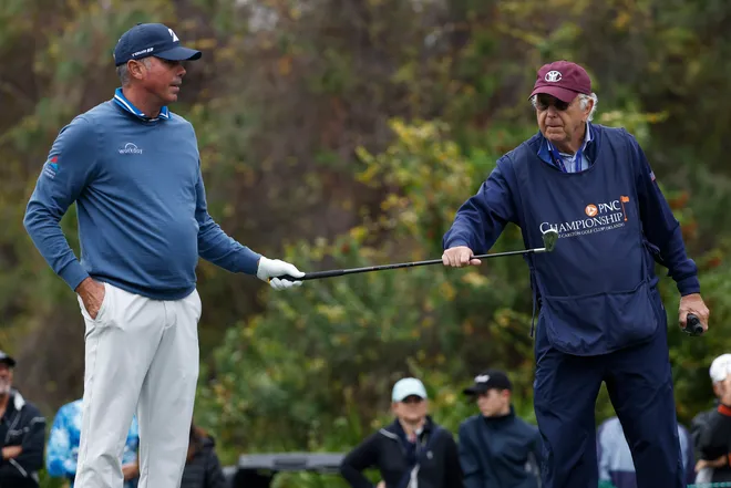 Matt Kuchar hands a club to his caddie and father, Peter, on the fourth hole during the final round of the 2023 PNC Championship at The Ritz-Carlton Golf Club.