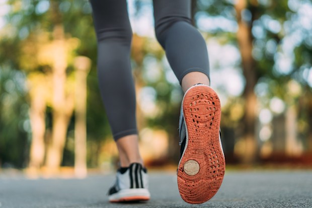Close-up shot of female runner feet in running shoes going for a run in the park.