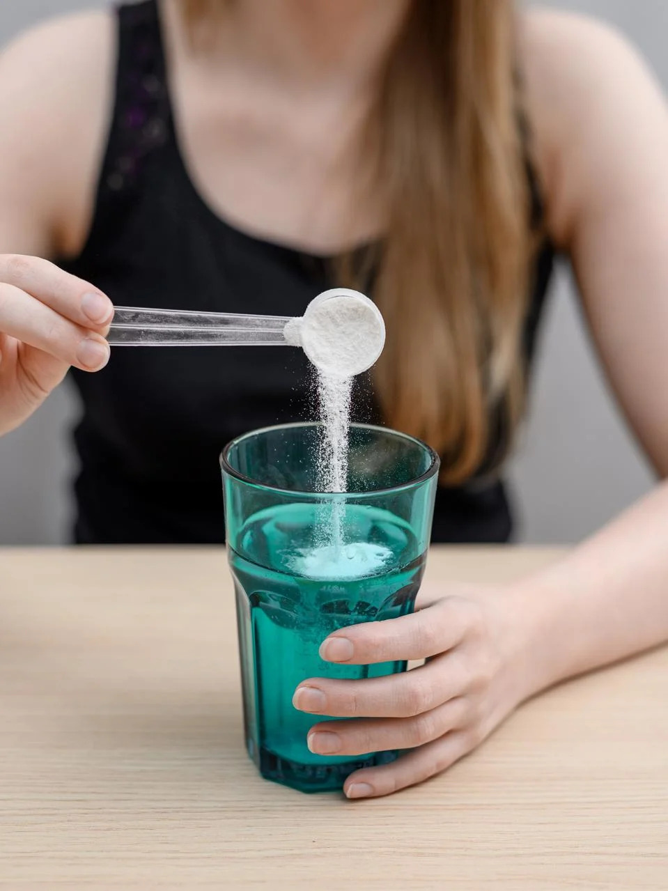 A woman with a migraine and a one-sided headache dissolves acetylsalicylic acid in a glass of water