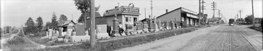1916: Exterior view of W.N. Bertram Marble Works, 4904 Fraser St., showing tombstones and monuments with a streetcar in the distance.