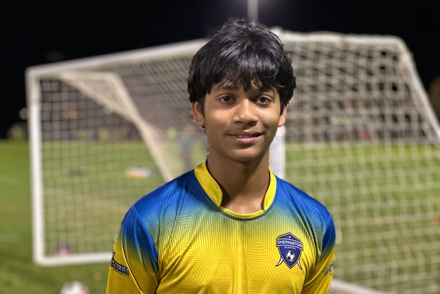 Close up of a young soccer player in front of a soccer goal