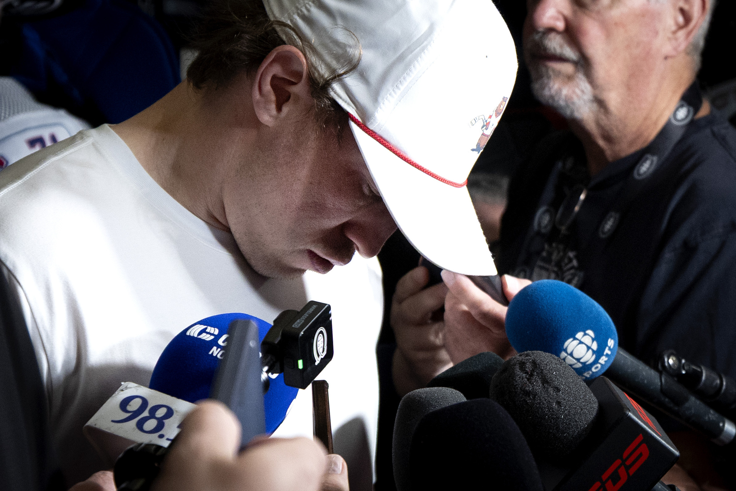 Brendan Gallagher has his head down while in a media scrum in a dressing room.
