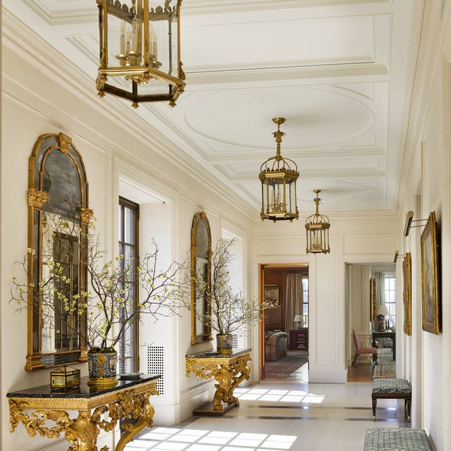 Elegant hallway with ornate decor, gold accents, and large windows. Elegant hallway with ornate decor, gold accents, and large windows.