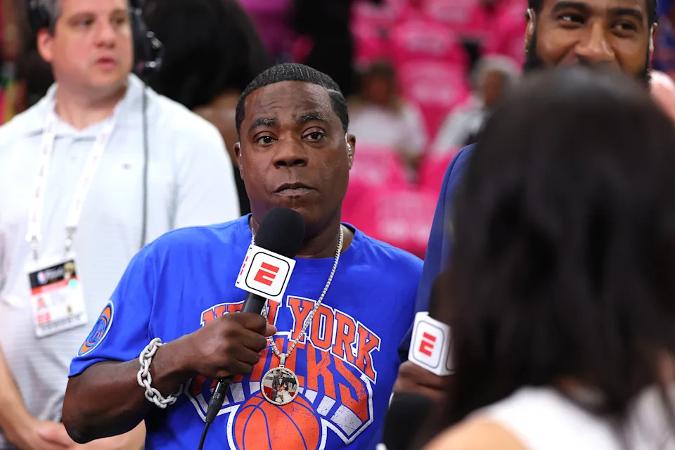 Tracy Morgan wearing a New York Knicks T-shirt and holding a microphone with the ESPN logo.