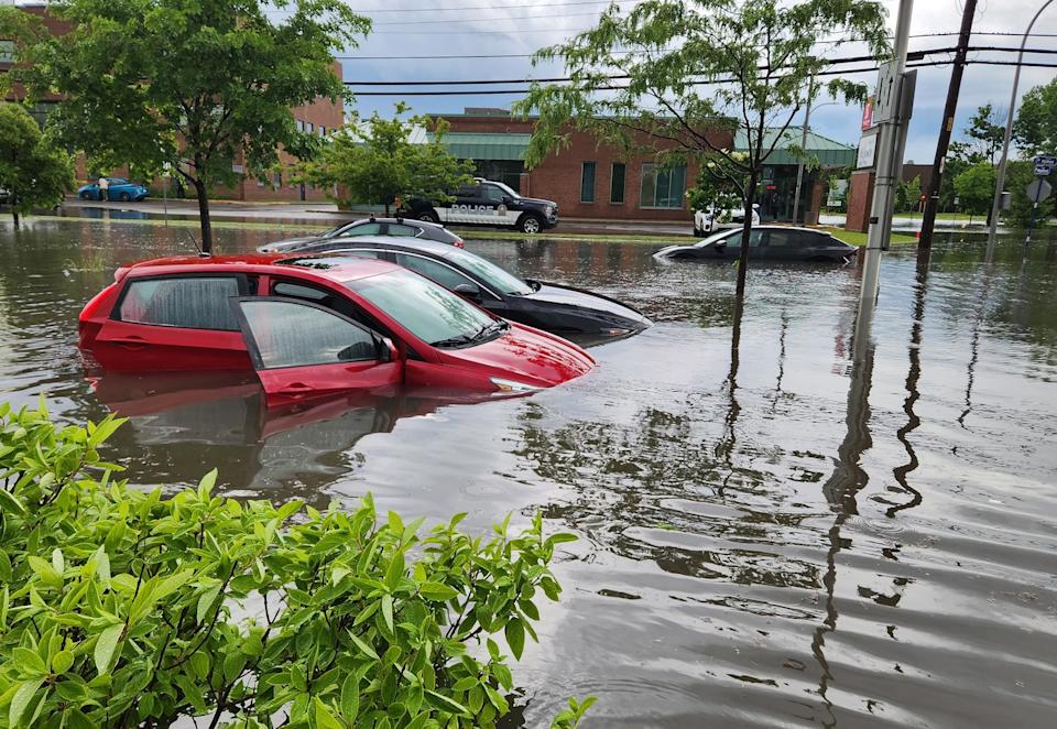 Abandoned cars sit on a flooded street in Montreals west island borough of Pointe Claire during a severe rainstorm on Saturday June 20, 2026. Local roads and highway 40 were closed during the downpour. THE CANADIAN PRESS/Peter McCabe - The Canadian Press