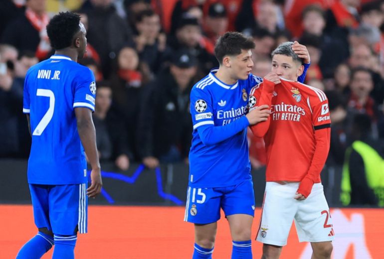 SL Benfica's Argentine forward #25 Gianluca Prestianni hides his mouth while arguing with Real Madrid's Brazilian forward #07 Vinicius Junior who complained about alleged racists insults during the UEFA Champions League knockout round play-off first leg football match between SL Benfica and Real Madrid CF at Estadio da Luz in Lisbon on February 17, 2026. (Photo by PATRICIA DE MELO MOREIRA / AFP)