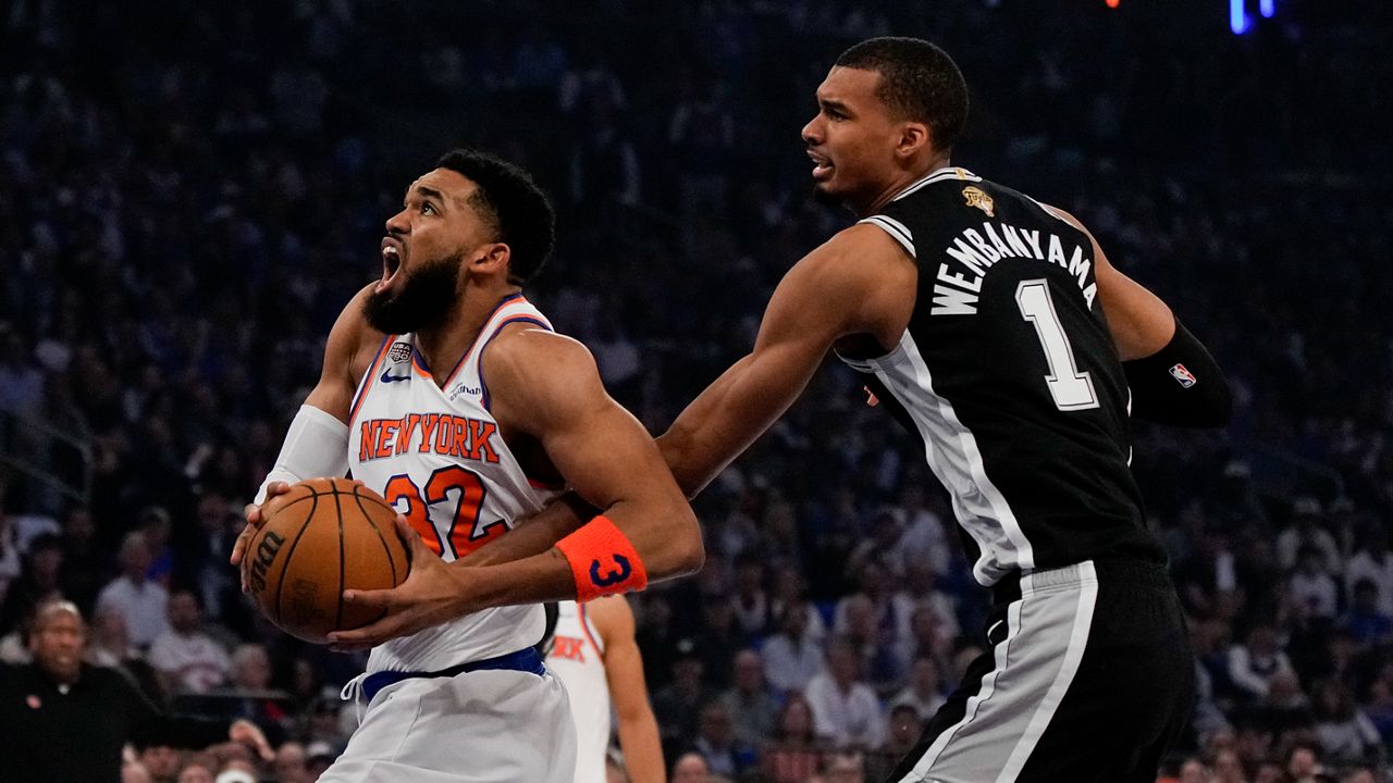 New York Knicks center Karl-Anthony Towns (32) drives past San Antonio Spurs forward Victor Wembanyama during first half of Game 4 of the NBA Finals basketball series, Wednesday, June 10, 2026, in New York. (AP Photo/Ross D. Franklin)