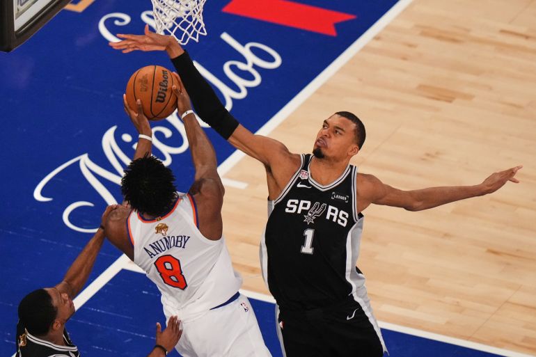 New York Knicks forward Og Anunoby (8) tries to shoot over San Antonio Spurs forward Victor Wembanyama (1) during the first half of Game 4 of the NBA Finals basketball series, Wednesday, June 10, 2026, in New York. (AP Photo/Frank Franklin II)