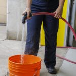 Person filling up a bucket with water to have in case of a firework incident.