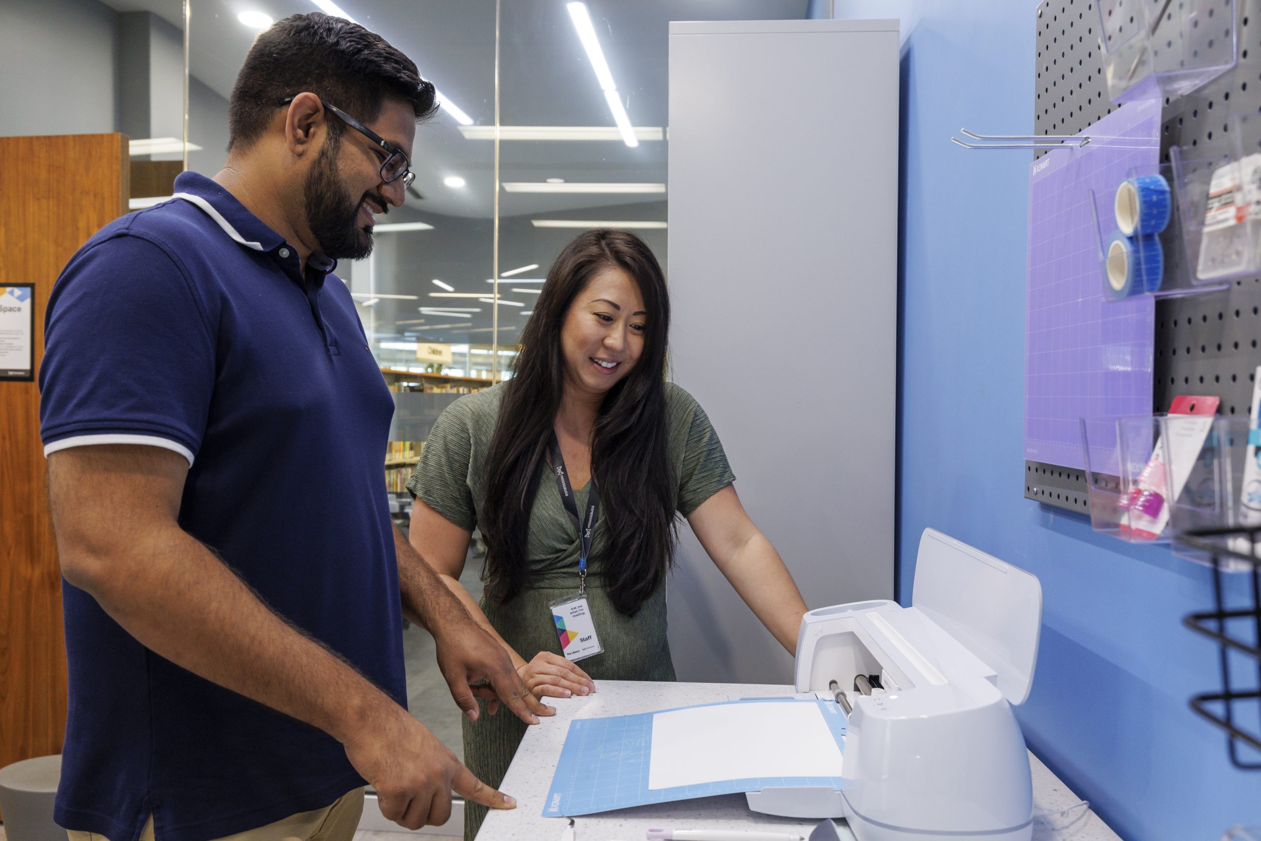 Library patrons using the cricut in the maker studio.