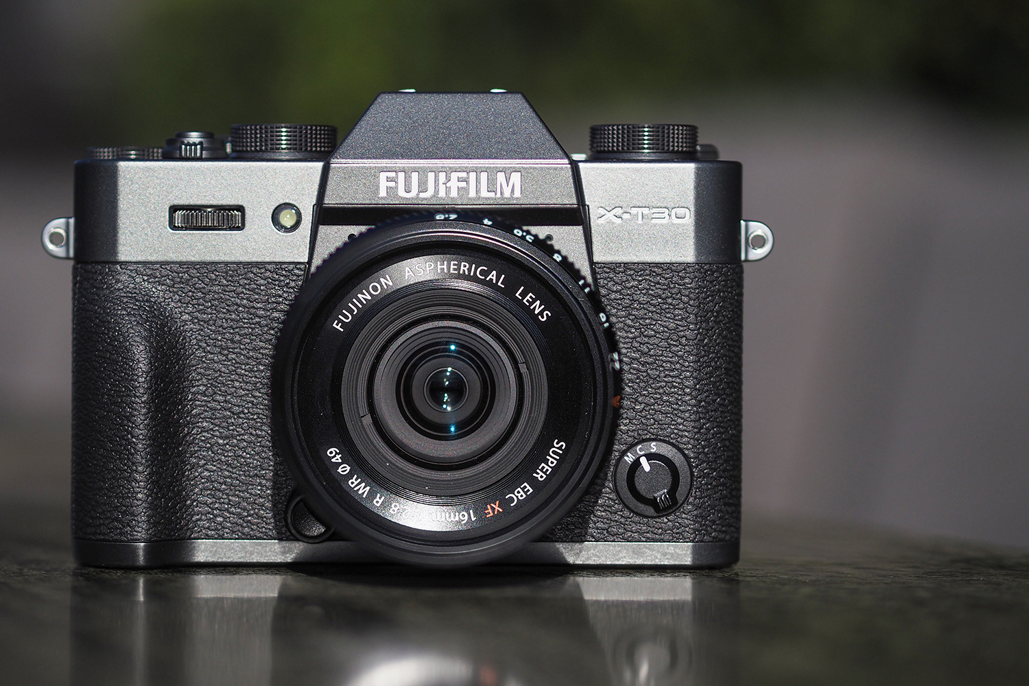 A Fujifilm X-T30 camera placed on a grey table