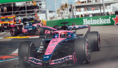 Front-right view of a pink Formula 1 car speeding on a race track with Heineken banners in the background.
