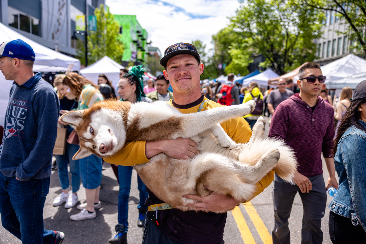 A person carrying a dog at a festival