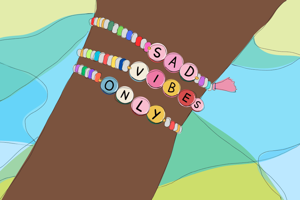 Illustration of a wrist with beaded bracelets that read "sad vibes only"