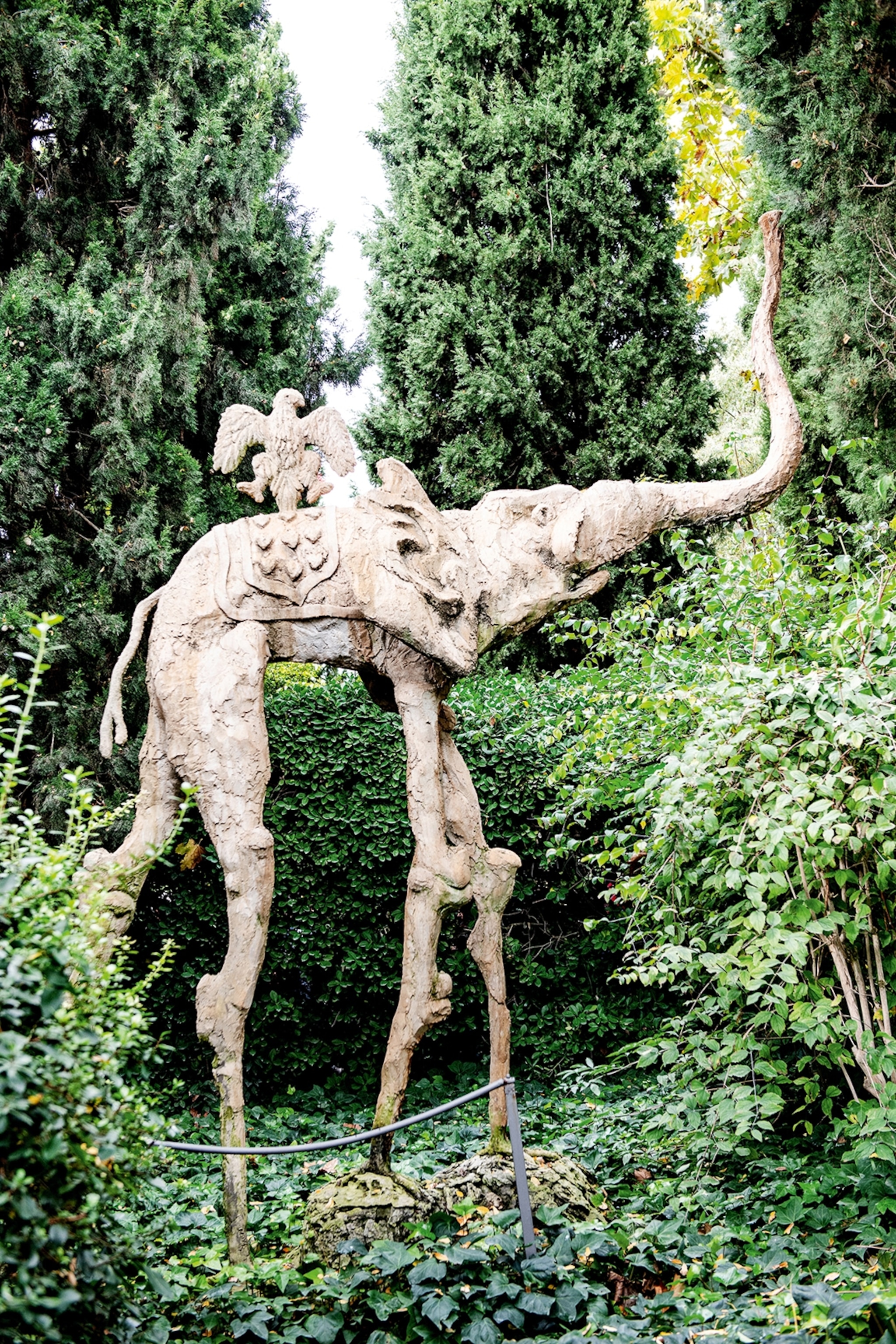 Elephant sculpture in greenery.