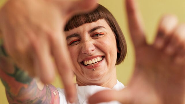 Portrait of cheerful woman making finger frame