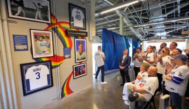 Attendees reacts during a ceremony prior to a baseball game to unveil a tribute to LGBTQ+ trailblazers and former Los Angeles Dodgers players Billy Bean and Glenn Burke, who were among the first professional athletes to identify as gay, Friday, June 5, 2026, in Los Angeles. (AP Photo/Mark J. Terrill)
