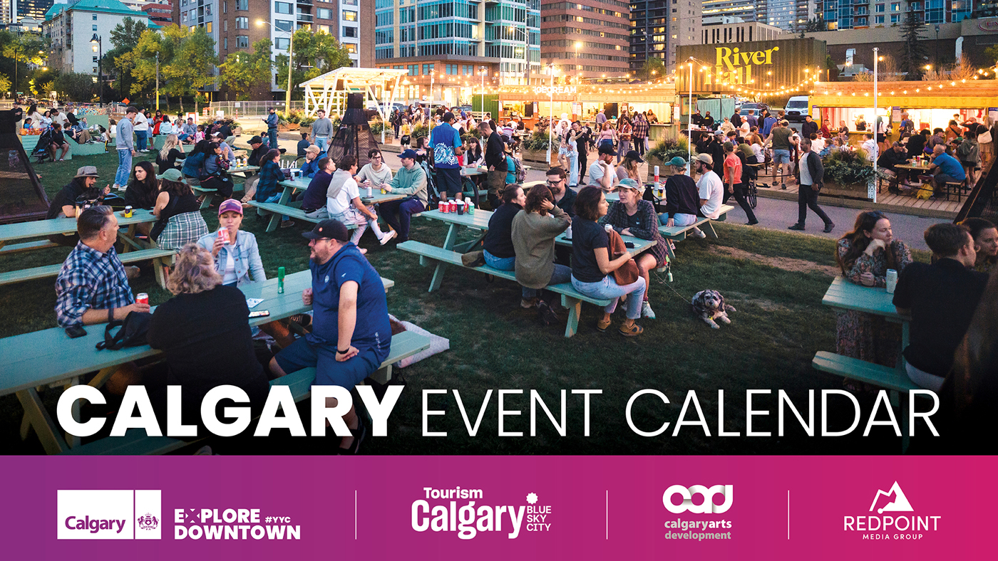 People sitting at picnic tables at an outdoor gathering.