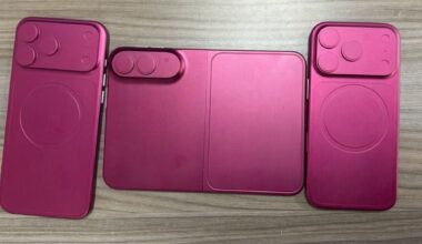 Three pink magenta phone cases laid out on a wooden surface, showing camera cutouts and a foldable center panel (wallet style).