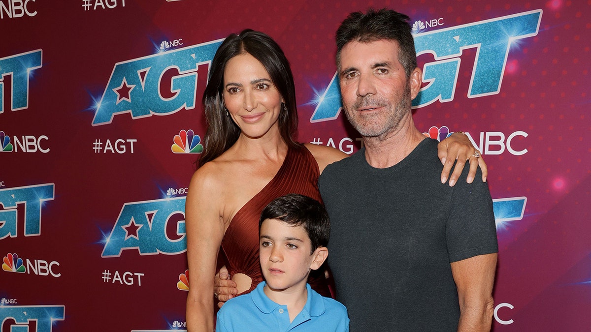 Lauren Silverman Simon Cowell and their son Eric Cowell posing at a red carpet event in Pasadena