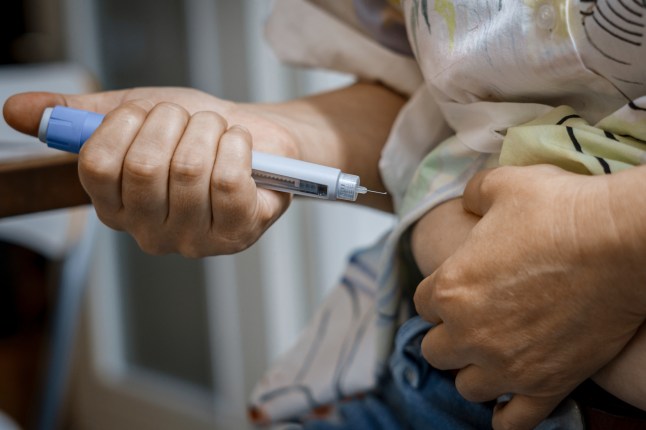 Person injecting semaglutide or insulin with injection pen