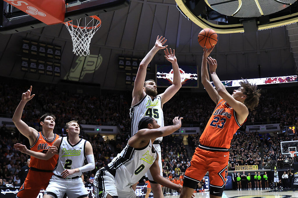 Illinios guard Keaton Wagler shoots short baseline jumper over two Purdue defenders during an NCAA basketball game.