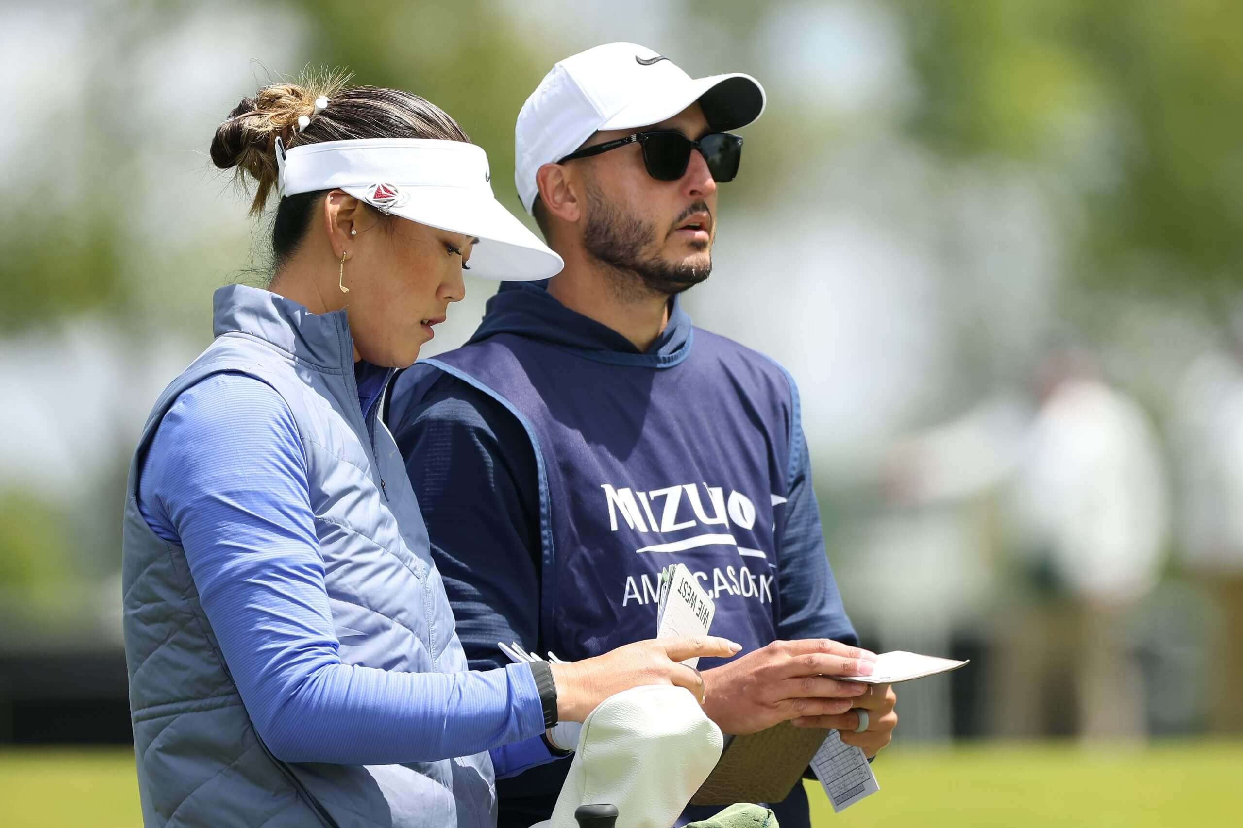 Michelle Wie West and her husband Johnnie examine their yardage books.