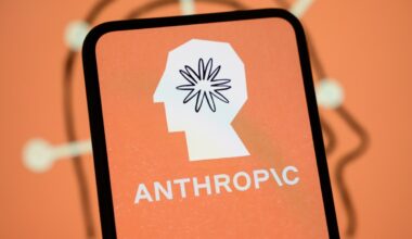 The Anthropic logo is displayed on the screen of a smartphone with the company's branding in the background.