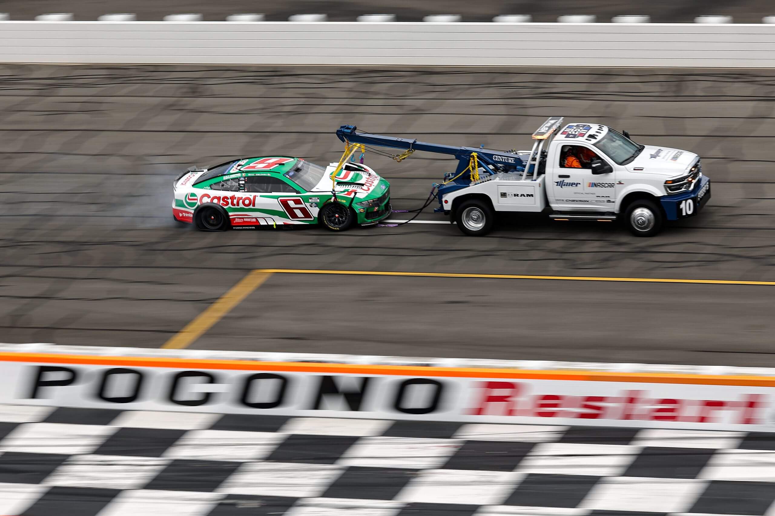 Brad Keselowski's car is towed off after Sunday's crash at Pocono.